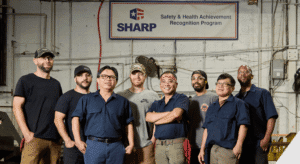 penn machine employees standing in front of OSHA SHARP banner